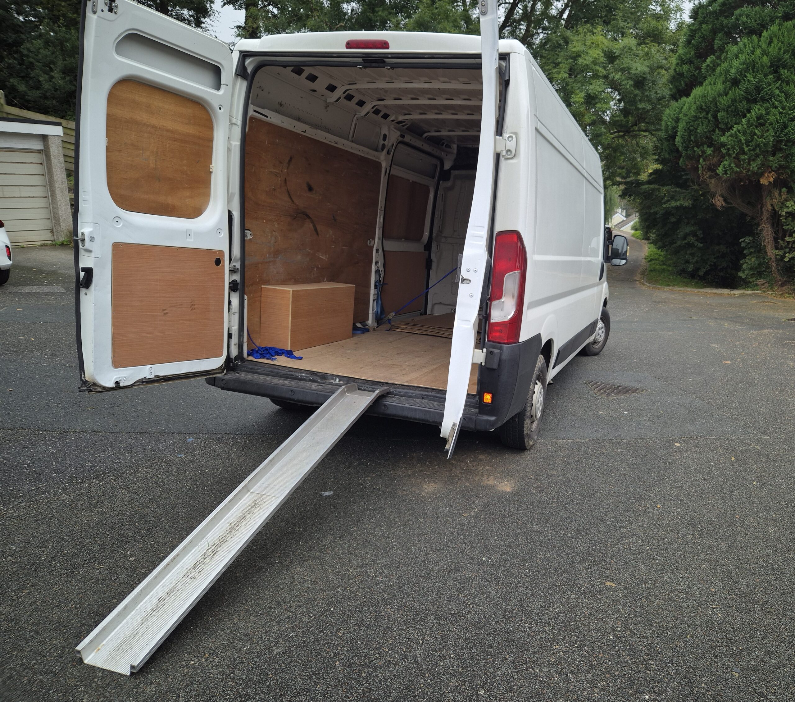 a white van with a motorcycle loading ramp - motorcycle delivery from £99